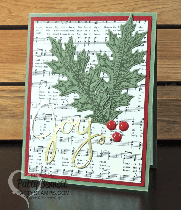 Handmade Christmas card featuring muscial score paper from Stampin' Up! - Home for Christmas paper pack. Joy die cut from Wonderful Wreath framelits and Gold Foil Paper and Vintage Leaves bundle. Card accented with Red Enamel Dots, by Patty Bennett