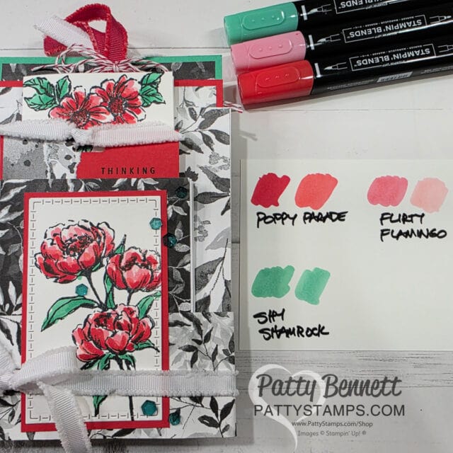 A handmade floral card with red and pink peonies, green leaves, and “THINKING” on a red strip is displayed with three dual-tip markers and a color swatch labeled Poppy Parade, Flirty Flamingo, and Shy Shamrock. “Patty Bennett pattystamps.com” is written below. To read more, visit Patty Stamps (pattystamps.com)
