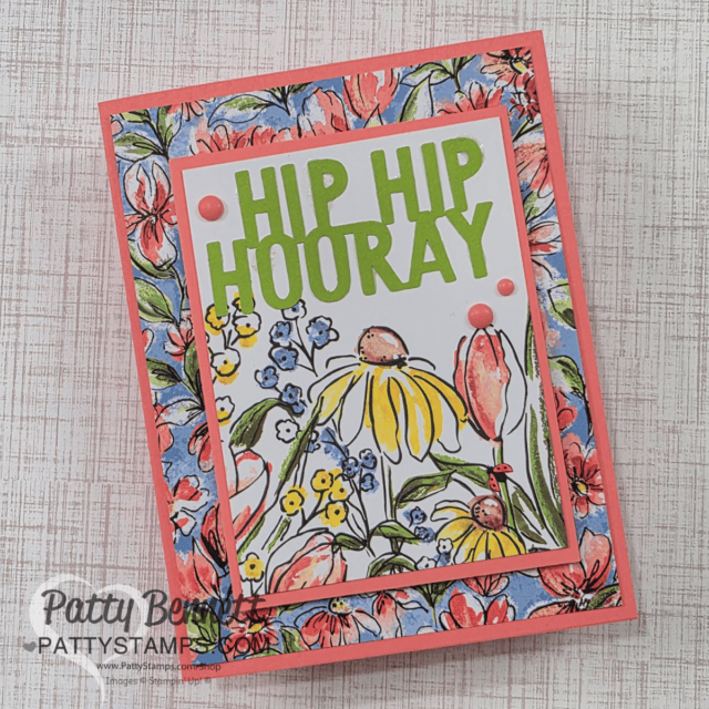 A colorful greeting card featuring the text "Hip Hip Hooray" in bold green letters. Below is an illustration of flowers, including daisies and other blooms. The card has a vibrant floral border on a textured background. Watermark: Patty Bennett, PattyStamps.com. To read more, visit Patty Stamps (pattystamps.com)