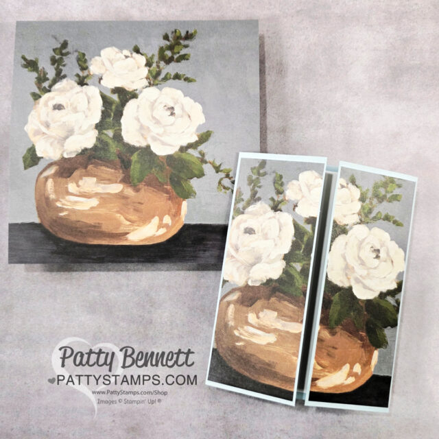 A painting of white flowers with green leaves in a round, tan vase on a gray background. The main artwork appears above two cropped versions, each on a light blue border. “Patty Bennett PattyStamps.com” is printed below the images. To read more, visit Patty Stamps (pattystamps.com)