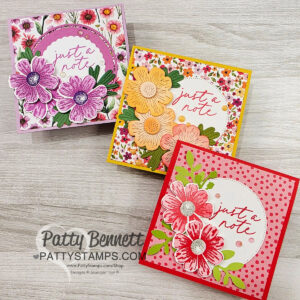 Three square handmade cards with floral designs and the phrase “just a note” in cursive. The top left card is purple-themed, the top right is yellow-orange, and the bottom right is red-pink. All are displayed on a light wood surface. To read more, visit Patty Stamps (pattystamps.com)