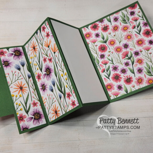 A handmade accordion-fold card with a green base. The card features panels decorated with colorful floral patterned paper in shades of pink, purple, orange, and yellow, with one blank white panel in the center for writing. "Patty Bennett, PattyStamps.com" watermark. To read more, visit Patty Stamps (pattystamps.com)