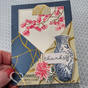 A handmade Pocket card with the Stampin Up! Kintsugi suite: thank you card featuring layered geometric shapes in blue, gold, and cream. It has a blue-patterned vase with a pink flower and leaves, a gold and pink cherry blossom branch, and a "thanks" message, all accented with delicate details. To read more, visit Patty Stamps (pattystamps.com)