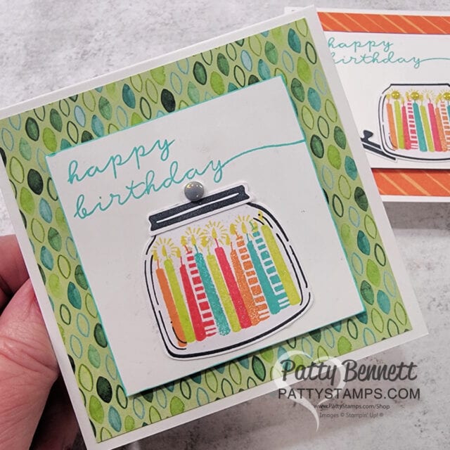 A handmade birthday card features colorful candles in a jar illustration on a white square, with "happy birthday" written in teal script above. The background is green with a leaf pattern. The card is signed "Patty Bennett pattystamps.com". To read more, visit Patty Stamps (pattystamps.com)