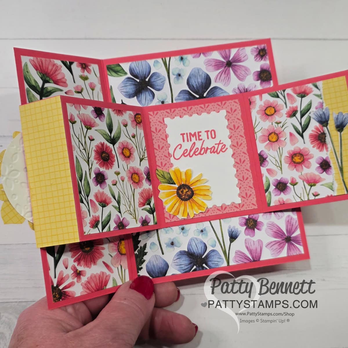 A handmade card with floral panels, a yellow checkered pattern on the left, and red borders. The center reads “Time to Celebrate” with a large yellow daisy. A hand with pink nail polish holds the card. “Patty Bennett PattyStamps.com” watermark is at the bottom. To read more, visit Patty Stamps (pattystamps.com)