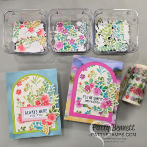 Unique arch cards with washi tape. Three clear trays contain colorful floral die-cuts. Below them are two handmade greeting cards decorated with similar bright flower arrangements. One card says “ALWAYS HERE FOR YOU,” the other says “YOU’RE SIMPLY incredible.” A floral tape roll is on the right. To read more, visit Patty Stamps (pattystamps.com)