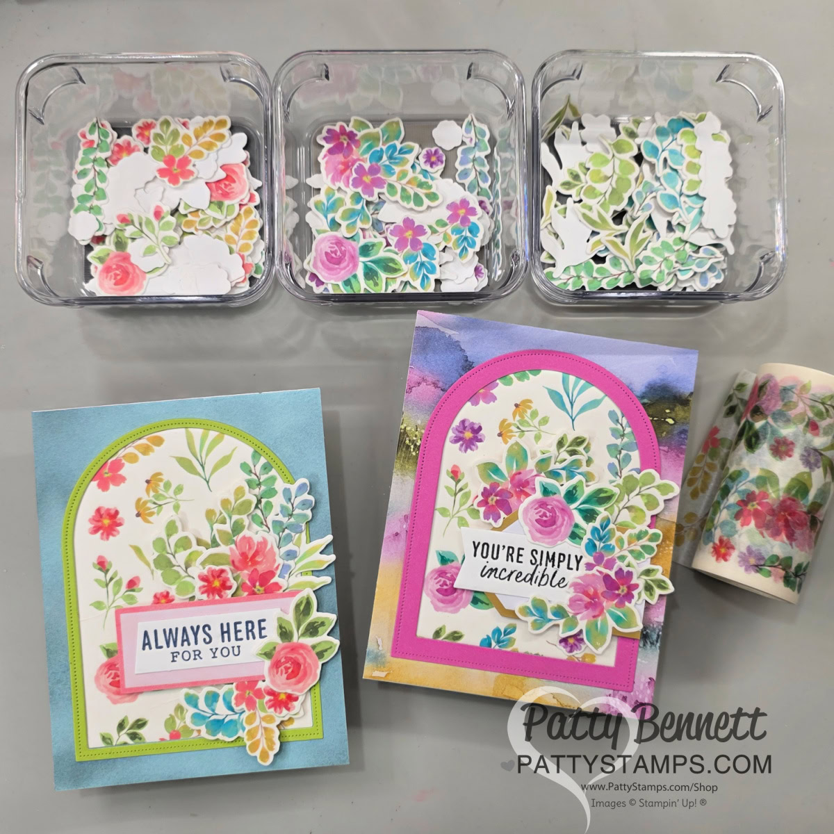 Unique arch cards with washi tape. Three clear trays contain colorful floral die-cuts. Below them are two handmade greeting cards decorated with similar bright flower arrangements. One card says “ALWAYS HERE FOR YOU,” the other says “YOU’RE SIMPLY incredible.” A floral tape roll is on the right. To read more, visit Patty Stamps (pattystamps.com)