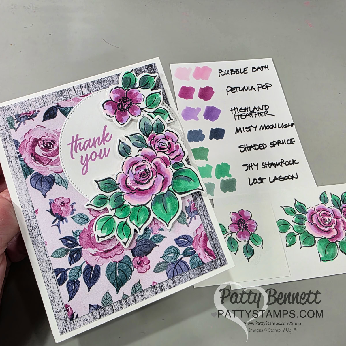 A hand holds a floral “thank you” card with pink and purple roses and green leaves on a patterned background. Next to it is a swatch card with paint samples labeled “Bubble Bath,” “Petunia Pop,” “Highland Heather,” “Misty Moonlight,” “Shaded Spruce,” “Shy Shamrock,” and “Lost Lagoon.”. To read more, visit Patty Stamps (pattystamps.com)
