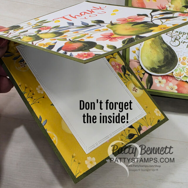 A hand holds an open handmade greeting card decorated with watercolor-style pears and flowers. The inside is blank with a white panel bordered by a yellow floral design. Black text reads, "Don't forget the inside!" The PattyStamps logo is visible at the bottom. To read more, visit Patty Stamps (pattystamps.com)