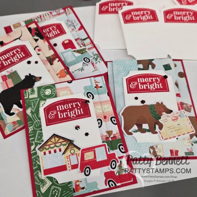 A set of handmade holiday cards features red “merry & bright” tags with festive backgrounds of bears, trucks, trees, and cabins. The cards have red borders and winter-themed patterns, with some matching envelopes visible. "Patty Bennett" watermark is present. To read more, visit Patty Stamps (pattystamps.com)