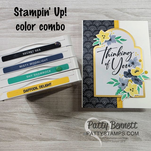 Color Combo for Flower Card with Christmas Greenery set. A handmade card reading “Thinking of You” is decorated with yellow, green, and gray florals on a black-and-white patterned background. Next to it are four stacked Stampin’ Up ink pads labeled Secret Sea, Misty Moonlight, Shy Shamrock, and Daffodil Delight. To read more, visit Patty Stamps (pattystamps.com)