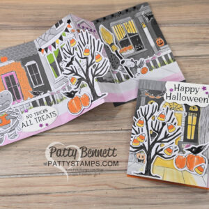 Fun Halloween Accordion card. A handmade, folded Halloween card features a festive street scene with decorated houses, pumpkins, candy corn, and trees. The card reads "NO TRICKS ALL TREATS" and "Happy Halloween." The creator’s logo, Patty Bennett, is visible on the wood background. To read more, visit Patty Stamps (pattystamps.com)