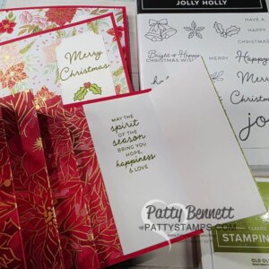 A handmade Christmas card with red and gold poinsettia designs is open, revealing the inside message: "May the spirit of the season bring you hope, happiness & love." Stamps, stamp sets, and another card with “Merry Christmas” are nearby. To read more, visit Patty Stamps (pattystamps.com)