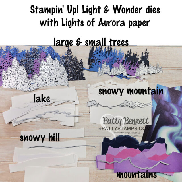 Die-cut paper shapes are arranged on a table, labeled as large & small trees, snowy mountain, lake, snowy hill, and mountains. The trees are blue, purple, and white while other shapes are cut from white, blue, and printed scenic paper. Text is overlaid at the top. To read more, visit Patty Stamps (pattystamps.com)