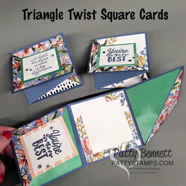 Three handmade, folded Triangle Twist Square Cards with floral borders and encouraging messages are displayed on a gray surface. One card is held open, showing its geometric folds and blank writing space. Text reads: "Triangle Twist Square Cards. To read more, visit Patty Stamps (pattystamps.com)