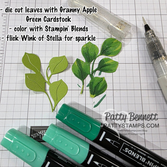 A grid-patterned workspace shows two die-cut green leaf clusters, one plain and one shaded with darker green and sparkle. Nearby are three Stampin’ Blends markers, a Wink of Stella glitter pen, and instructions for coloring and adding sparkle to the leaves. To read more, visit Patty Stamps (pattystamps.com)
