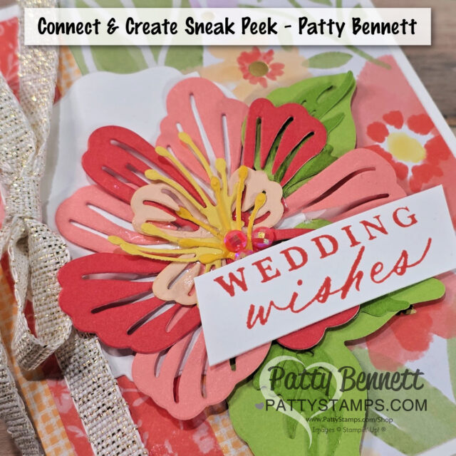 Connect & Create retreat sneak peek A layered paper flower in pink, red, and yellow is the centerpiece of this Stampin’ Up wedding card, perfect for a demonstrator event. “WEDDING wishes” in red accents a white label, with sparkly ribbon and a vibrant floral background from pattystamps. To read more, visit Patty Stamps (pattystamps.com)