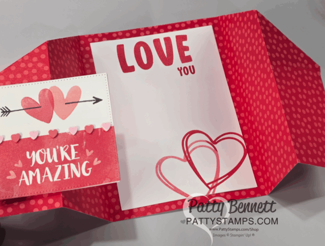 A handmade Valentine’s card with red polka-dot edges features a fun fold design, two overlapping heart outlines, and bold “LOVE YOU” text. Left flap shows pink hearts pierced by an arrow and “YOU’RE AMAZING.” "Patty Bennett" watermark at bottom. To read more, visit Patty Stamps (pattystamps.com)