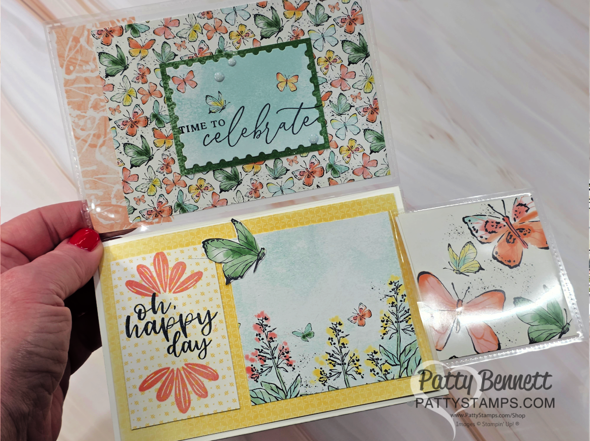 A hand holds two handmade greeting cards with butterfly and floral designs. One card says "time to celebrate" and has colorful butterflies, while the other says "oh, happy day" with yellow flowers and a large butterfly. Both are bright and cheerful. To read more, visit Patty Stamps (pattystamps.com)