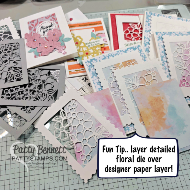 A collection of handmade greeting cards with intricate floral die-cut designs layered over colorful designer paper rests on a craft table. Some cards display flowers and sentiments like "Thank you." A tip on the image suggests layering die-cuts over designer paper. To read more, visit Patty Stamps (pattystamps.com)
