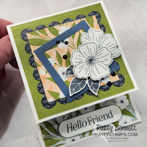 A handmade greeting card features layered, scalloped, and square papers with floral designs in green, blue, and peach. At the center are outlined white flowers with leaves. The card reads "Hello Friend" and is credited to Patty Bennett at pattystamps.com. To read more, visit Patty Stamps (pattystamps.com)