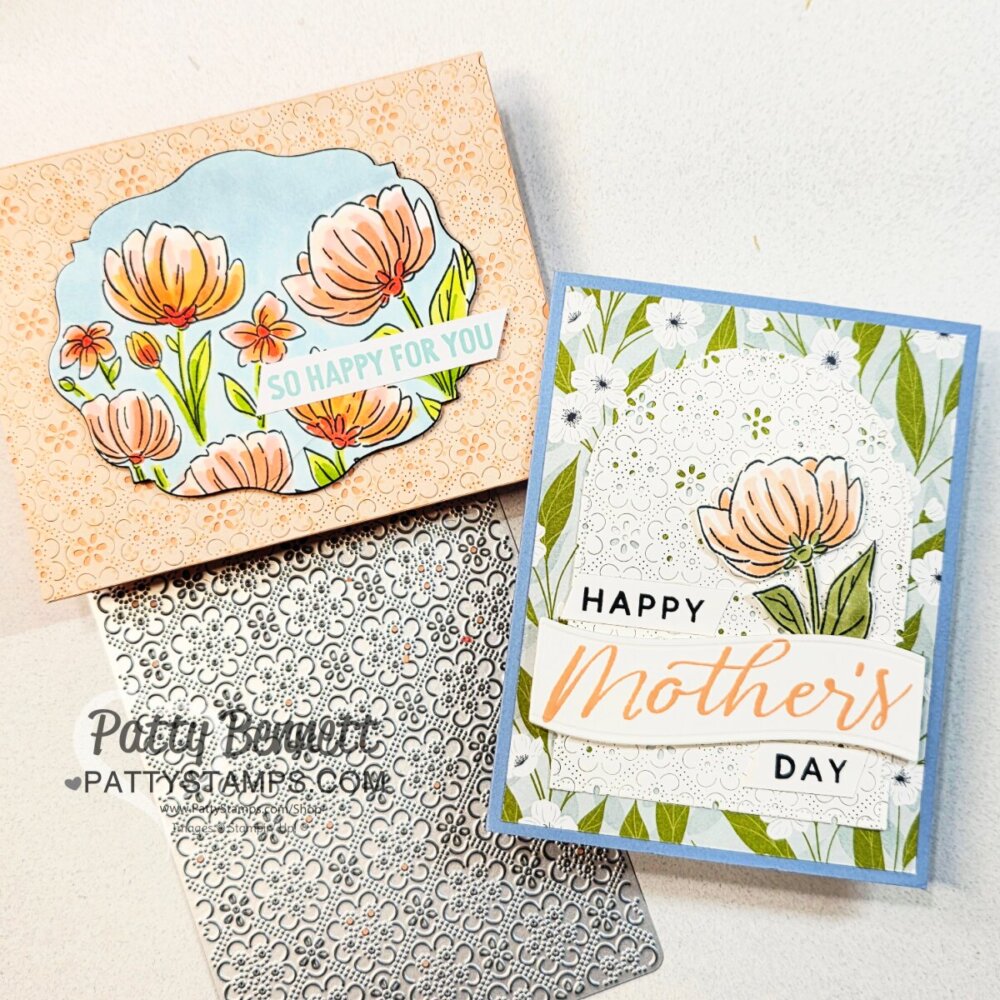Two handmade Mother's Day cards with floral designs are shown. One card is peach with illustrated orange flowers and reads “So happy for you.” The other is blue and white with floral patterns and says “Happy Mother’s Day.” A floral metal die sits below. To read more, visit Patty Stamps (pattystamps.com)