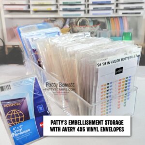 Clear acrylic containers hold neatly organized vinyl envelopes labeled with crafting embellishments. A blue pack of Avery 4"x6" vinyl envelopes is visible on the left. Text overlay reads: “PATTY’S EMBELLISHMENT STORAGE WITH AVERY 4X6 VINYL ENVELOPES.”. To read more, visit Patty Stamps (pattystamps.com)