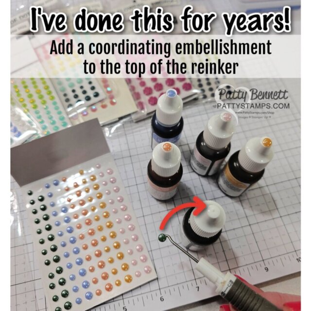 Bottles of ink reinkers each have a colored embellishment dot on their cap. A hand with tweezers places a green dot on a bottle. Sheets of colorful embellishments are nearby. Text instructs to add a coordinating embellishment on reinker tops for organization. To read more, visit Patty Stamps (pattystamps.com)