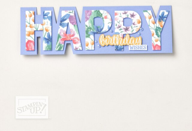 A card spells “HAPPY” in large floral-patterned letters on a blue background. Below “PY,” yellow and white words read “birthday wishes.” The bottom left corner shows a faint “Stampin’ Up!” logo. The background is off-white and mostly blank. To read more, visit Patty Stamps (pattystamps.com)