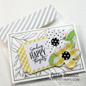 A handmade card with a black-and-white leaf border, featuring two layered flowers—one in yellow plaid, one in black-and-white polka dots. The card reads, "Sending HAPPY thoughts." The envelope has diagonal gray stripes. The card is by Patty Bennett. To read more, visit Patty Stamps (pattystamps.com)