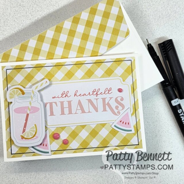 A handmade thank you card on a yellow plaid background, featuring a pink lemonade mason jar, lemon and watermelon slices, and the text “with heartfelt THANKS.” A matching envelope, two black pens, and a watermark “Patty Bennett PattyStamps.com” are visible. To read more, visit Patty Stamps (pattystamps.com)