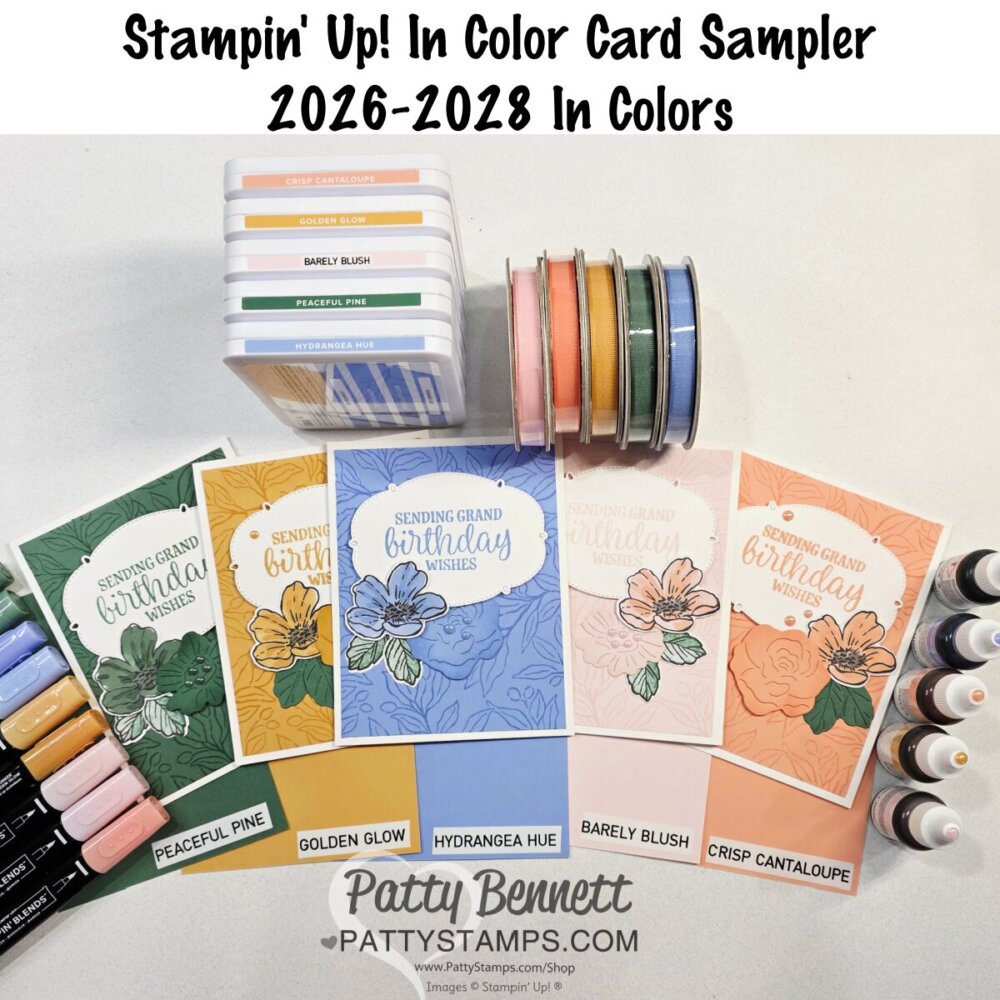 A display of Stampin’ Up! cardmaking supplies shows ink pads, markers, ribbon spools, ink bottles, and four floral cards labeled with colors: "Peculiar Pine," "Hydrangea Hue," "Petunia Pop," and "Crystantheum," plus text for "In Color Card Sampler 2026–2028. To read more, visit Patty Stamps (pattystamps.com)