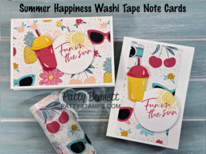 Two handmade summer-themed note cards feature colorful washi tape with cherries, sunglasses, and flowers. Each card has a bright drink and a round label reading “Fun in the sun.” Washi tape rolls are displayed below on a light blue wood background. To read more, visit Patty Stamps (pattystamps.com)