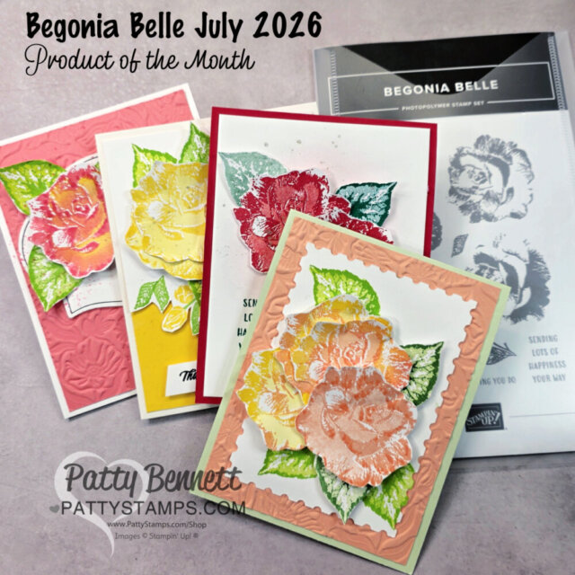 Four handmade floral greeting cards with layered, colorful stamped flowers in pink, red, yellow, and peach tones are arranged on a desk. Behind them is the Begonia Belle stamp set packaging. Text highlights "Begonia Belle July 2026 Product of the Month. To read more, visit Patty Stamps (pattystamps.com)